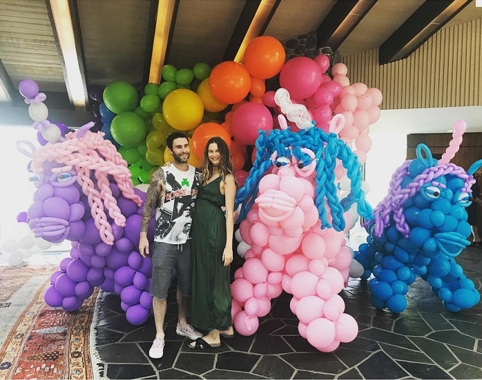 A picture of Adam and pregnant Behati in their first daughter's birthday.
